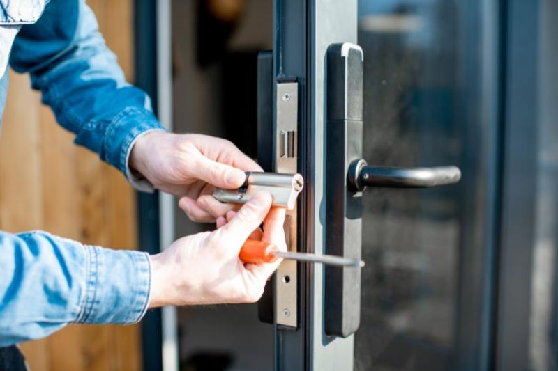 A man fitting a lock on a door