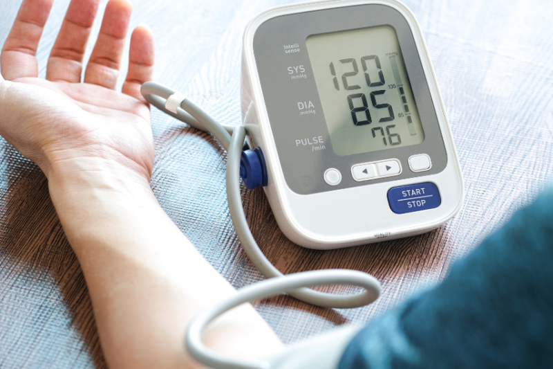 person having blood pressure taken with device