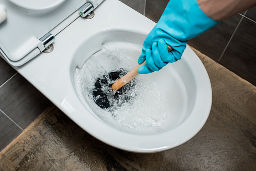 A toilet being plunged