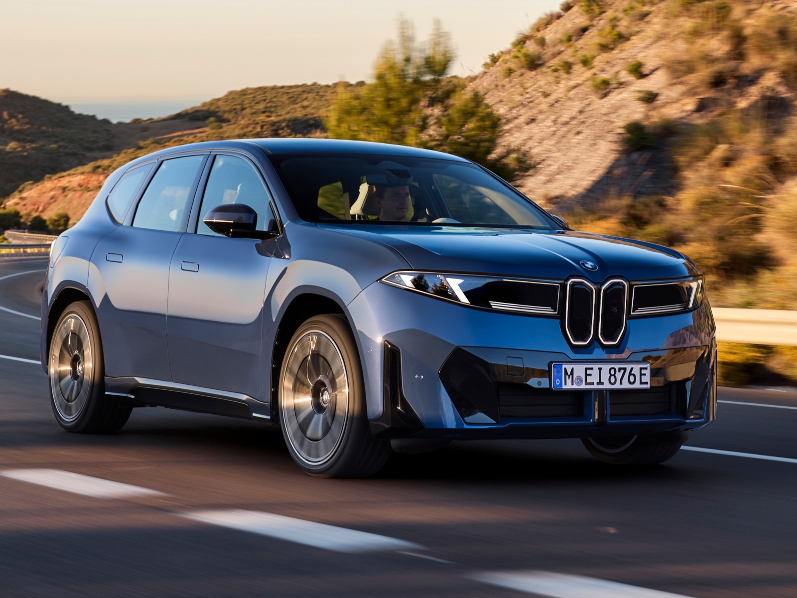A BMW iX3 car driving down a road