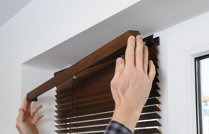 Image of a man installing the bracket for a Venetian blind
