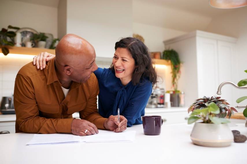 Image of a happy couple signing forms in a home