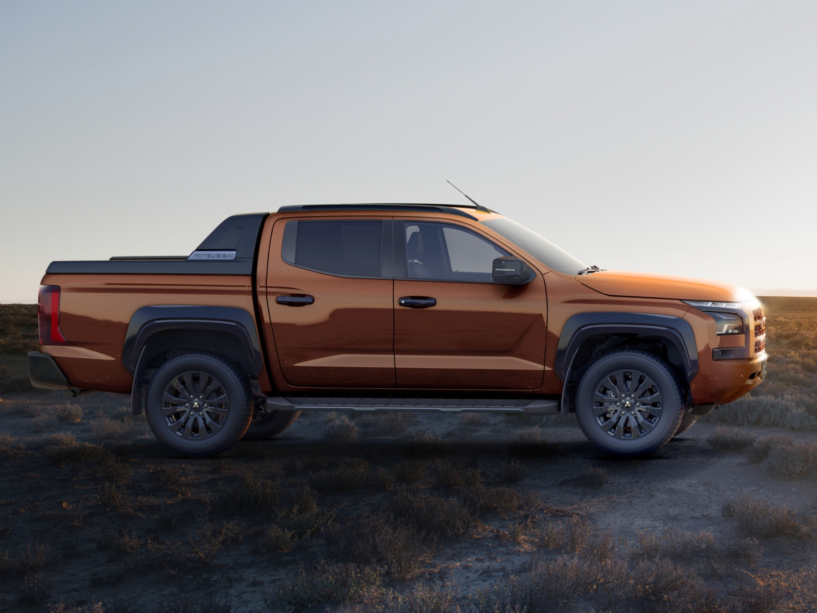 A orange Mitsubishi L200 pick-up truck parked