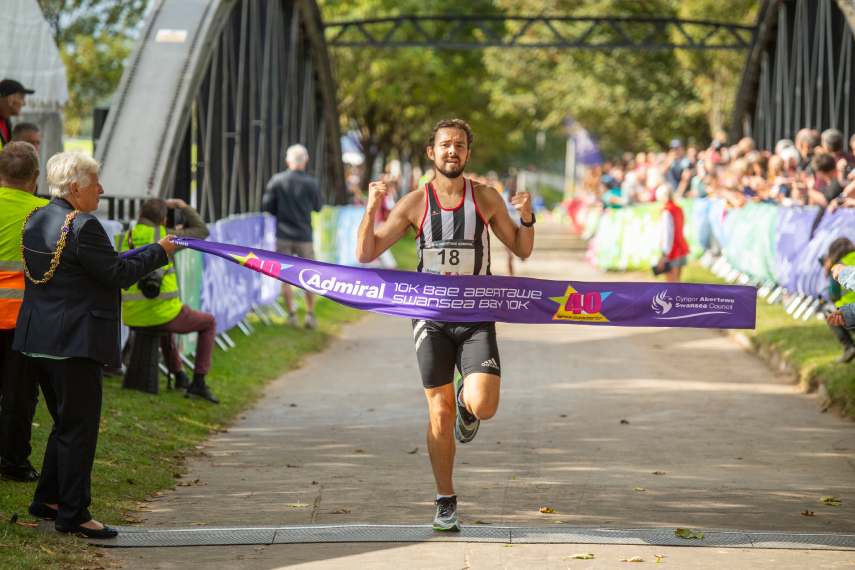 Image of a man crossing the Admiral 10K finish line