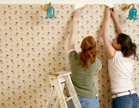 A couple wallpapering