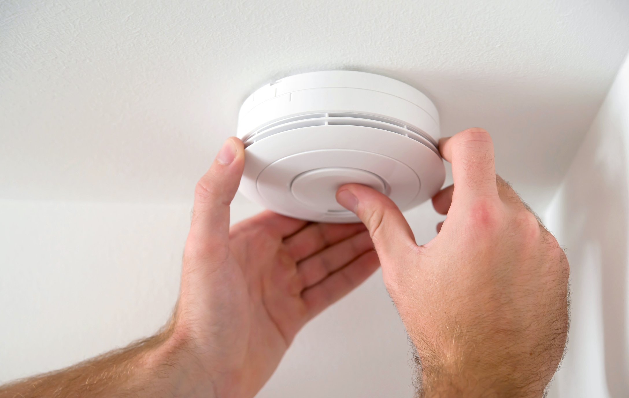 man installing smoke alarm