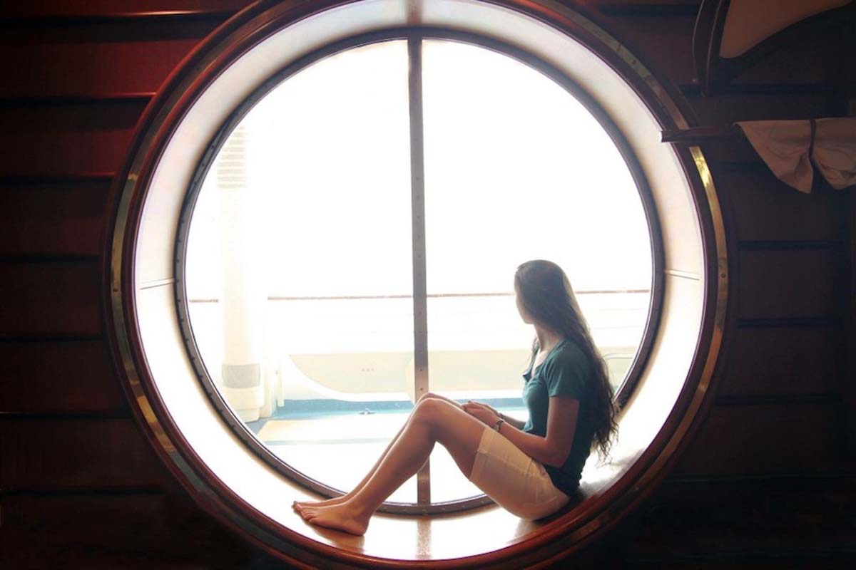 woman-sitting-at-window-of-cruise-ship