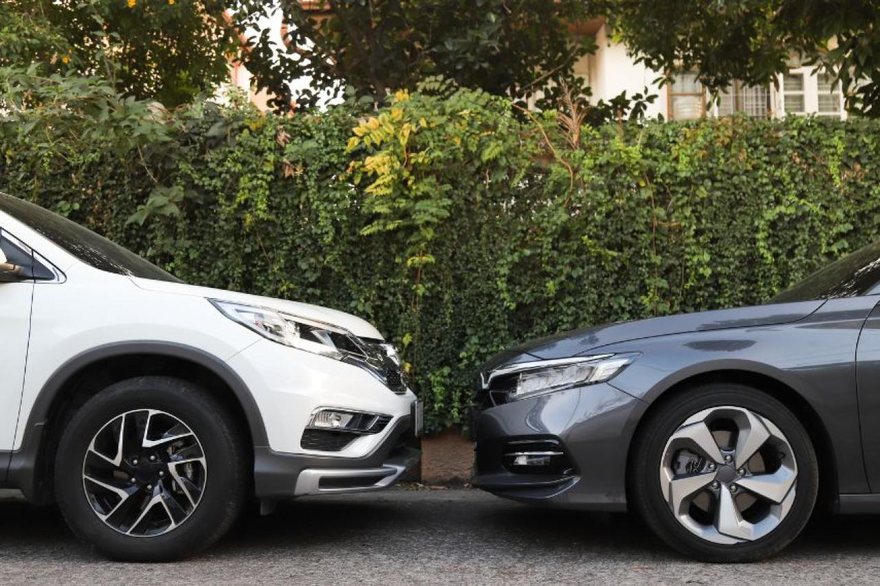 One grey and one white car facing each other