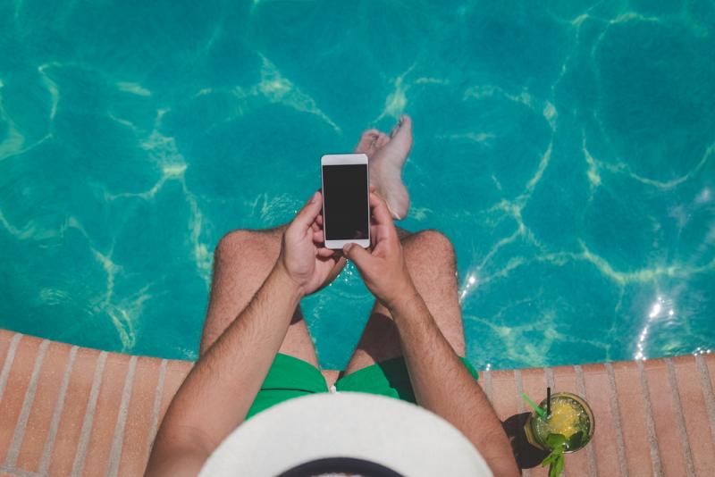 Man sitting by the tool with a mobile phone