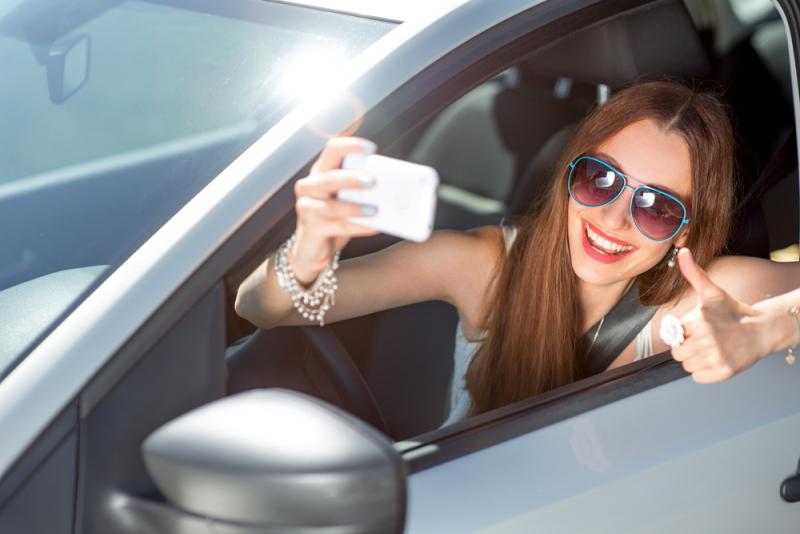 smiling-young-woman-taking-a-selfie-in-her-car.jpg