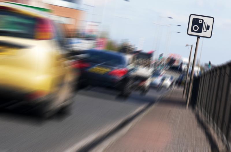 cars-driving-past-speed-camera-sign