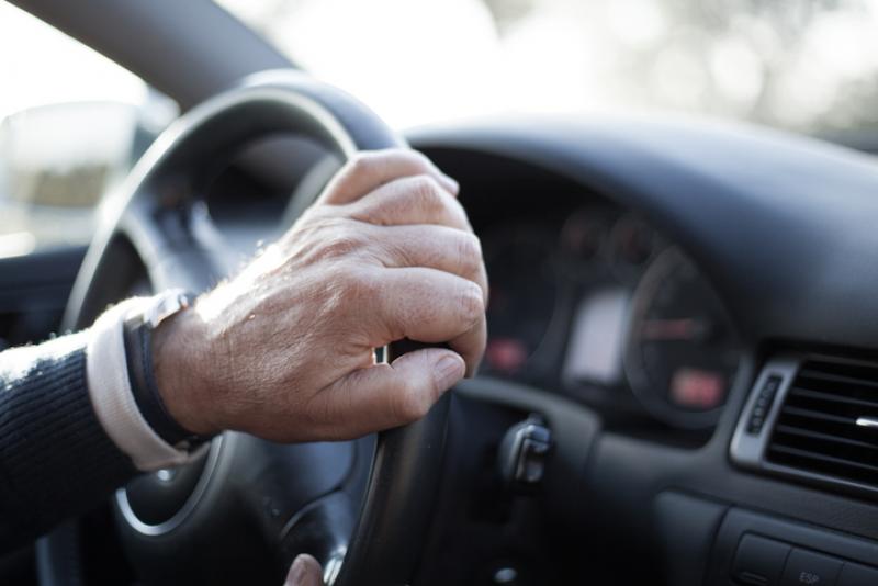 older-mans-hand-on-steering-wheel