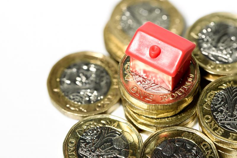 close-up-of-toy-house-on-pile-of-pound-coins