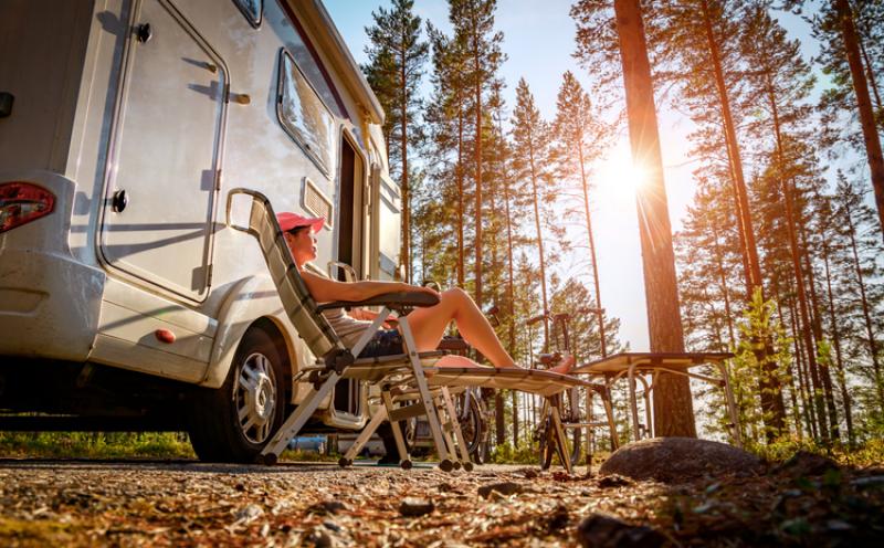 woman-sitting-outside-motorhome-on-holiday