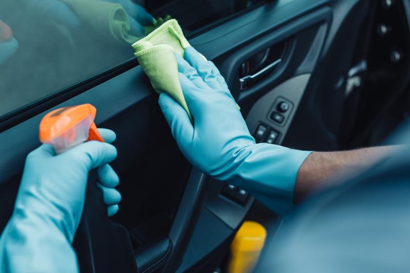 Person cleaning car dashboard