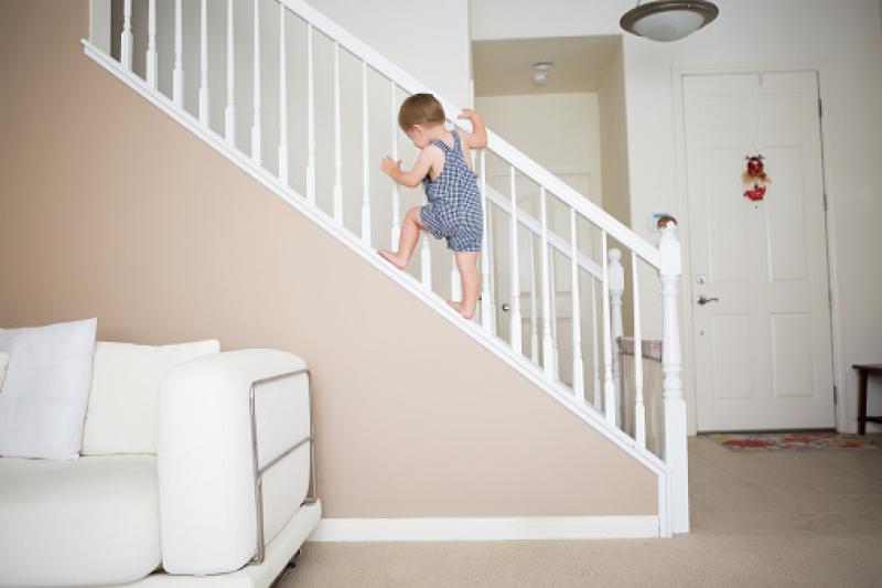 Child climbing up a banister