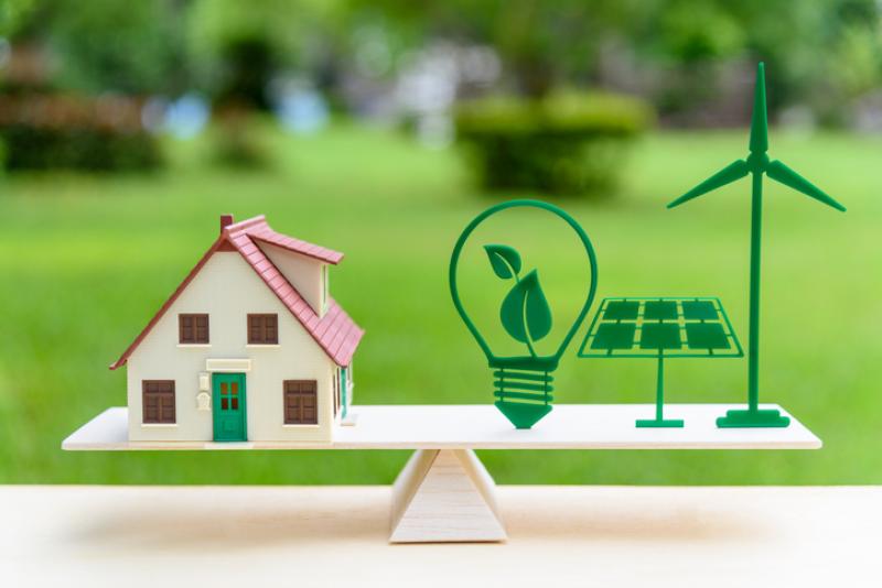 image of miniature home on scales with eco icons