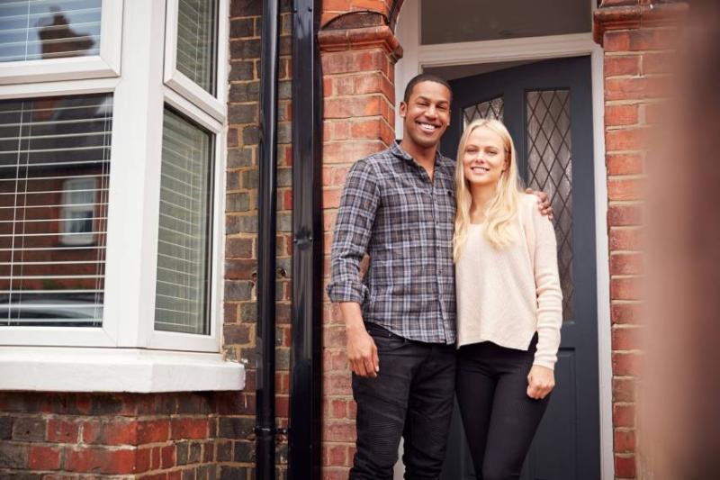 Image of a couple outside a house.