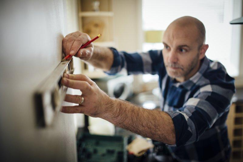 Image of man using a spirit level to put up a shelf