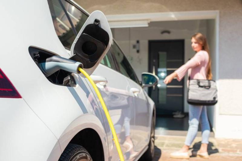 Image of woman charging her electric car. 