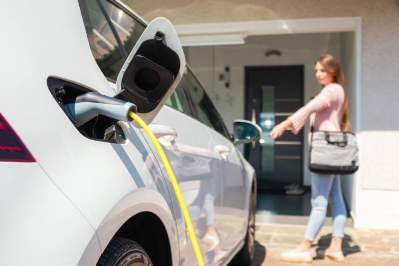 Image of woman charging her electric car.