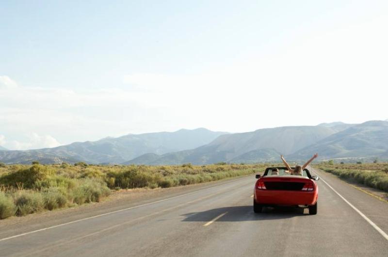 Image of a couple driving a sportscar