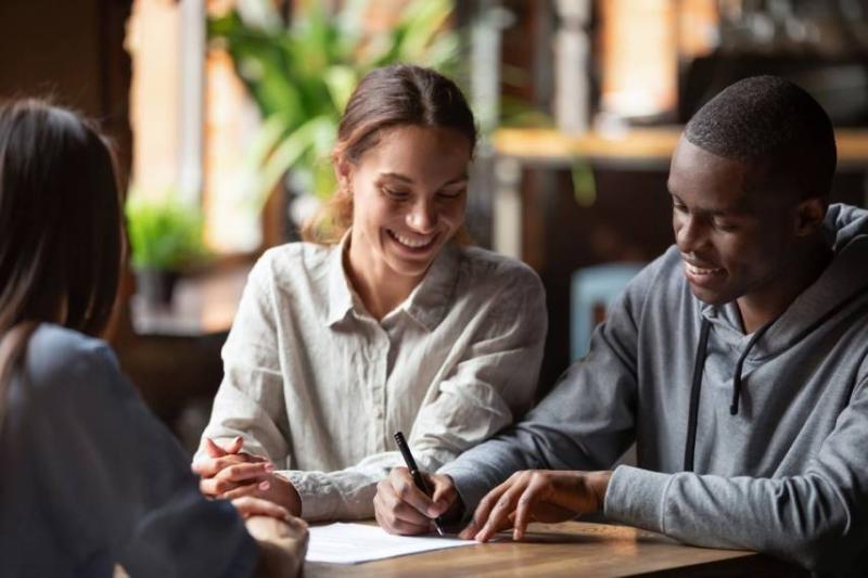 Image of a happy couple signing referencing forms