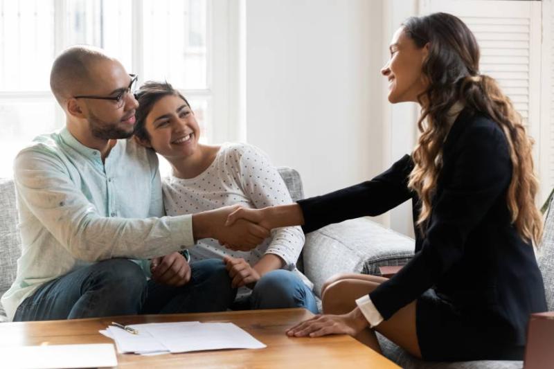 Image of a landlord and a couple after signing a rental agreement