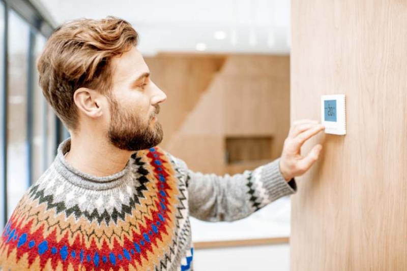 White man checking the thermostat