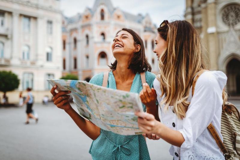 Two women looking at map and smiling