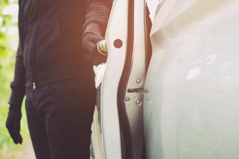 A gloved hand opening a car door