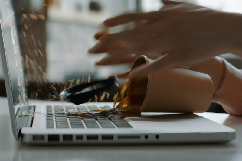 Someone spilling a coffee on a laptop.