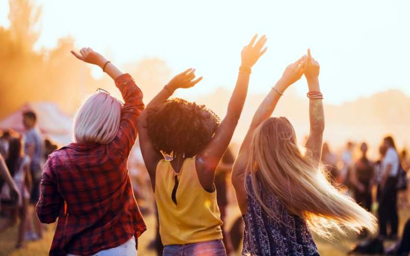 Three women at a festival dancing