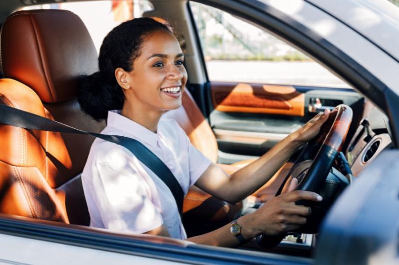 Woman driving car and smiling