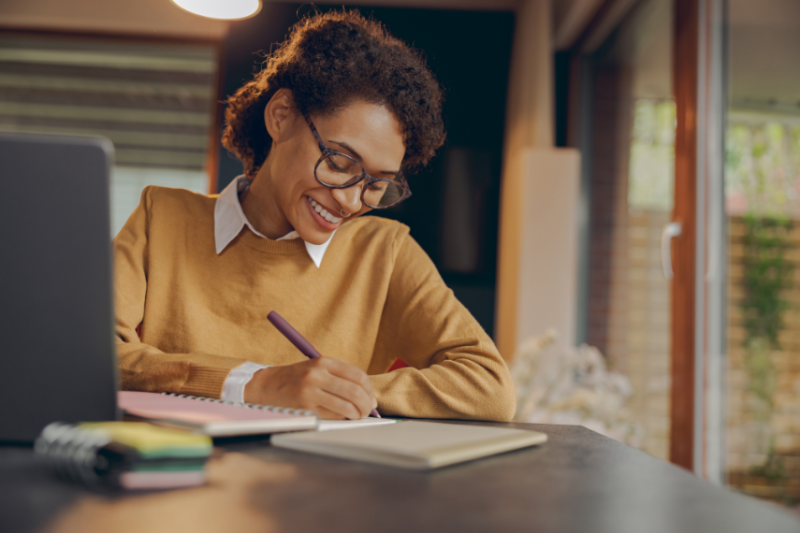 Woman with glasses making notes on paper