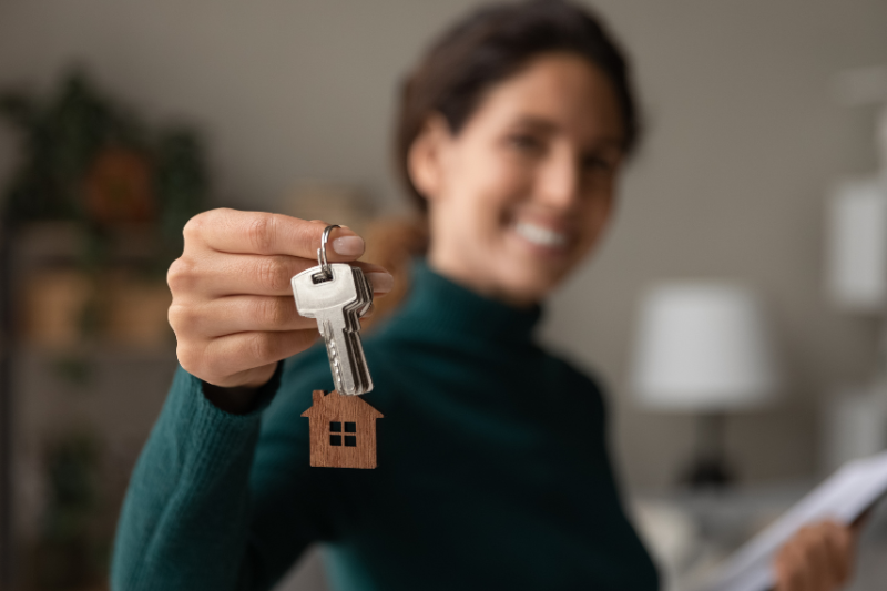Woman holding a set of keys with a house keyring on it