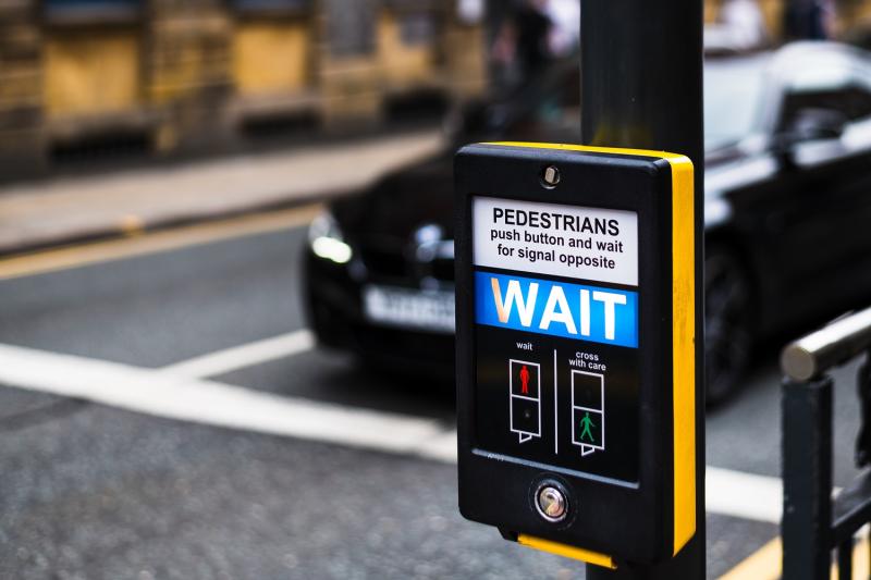 Pedestrian Crossing button that says WAIT for people to cross the road