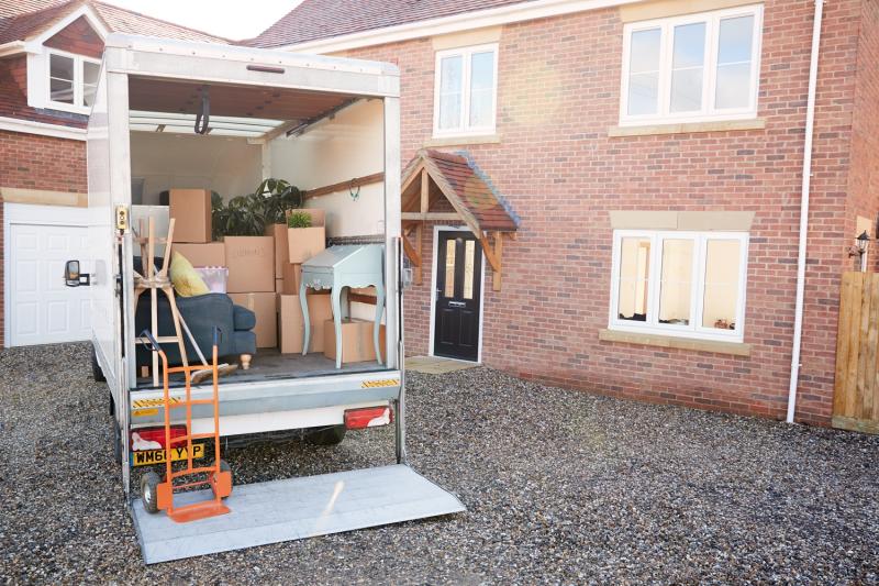 Removal Van Waiting To Be Unloaded Outside New Home On Moving Day