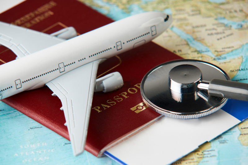 model plane and stethoscope lying on passport and map