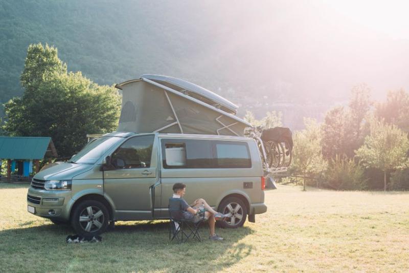 Man sat on camping chair beside campervan