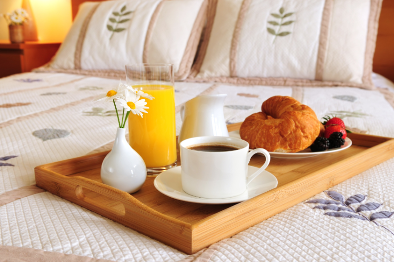 breakfast tray laid on hotel bed