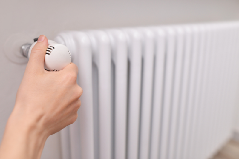 close up image of person adjusting radiator 
