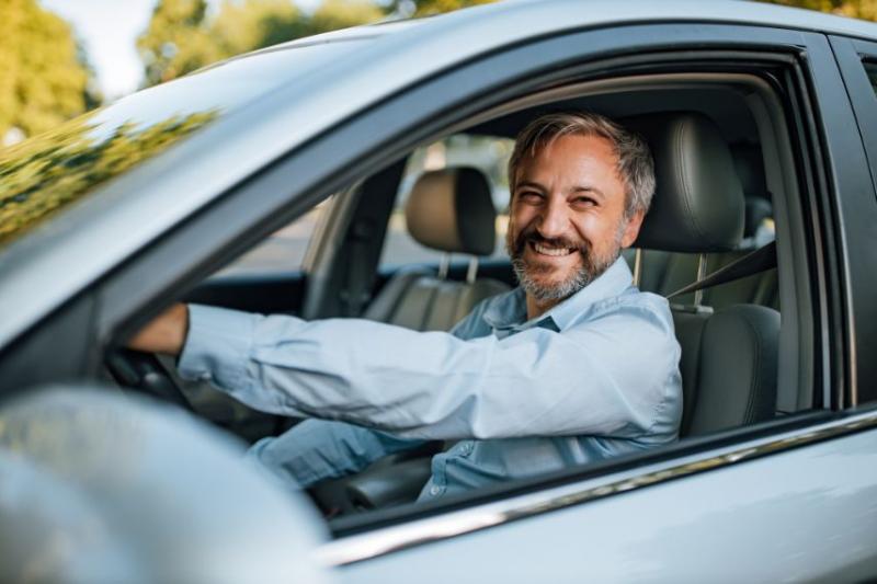 Grey-haired man sat in driver's seat of car