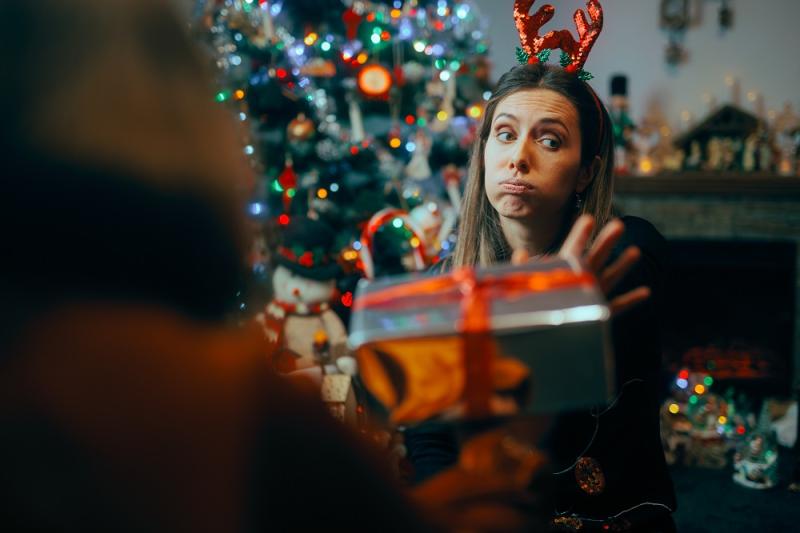 Ungrateful Woman Refusing a Christmas Gift from a Friend. Rude holiday party host rejecting presents from her guests