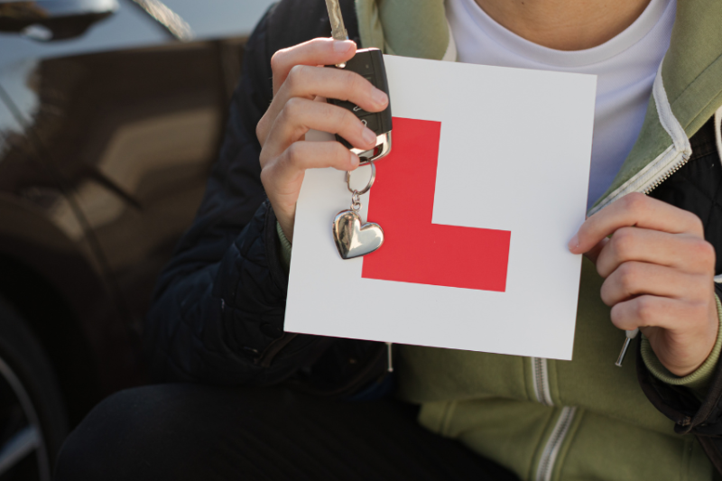 person holding learner sticker and keys