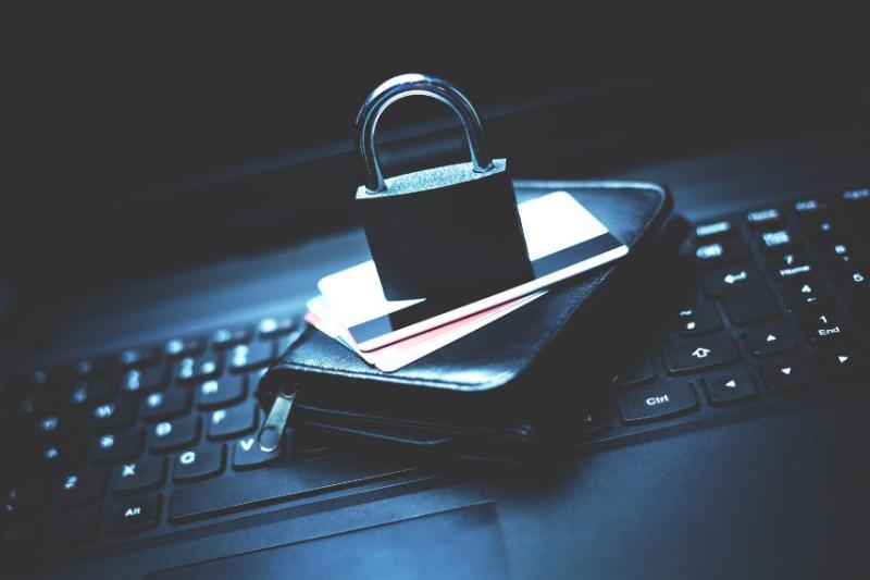 image of wallet on laptop keyboard with padlock on top