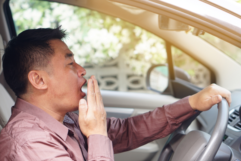 man coughing or yawning in car