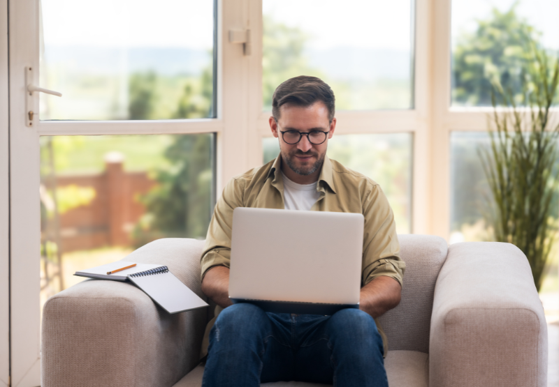 man with his laptop sitting on the sofa.