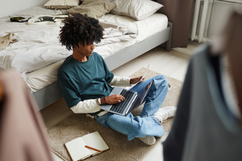 student on his laptop look at paper