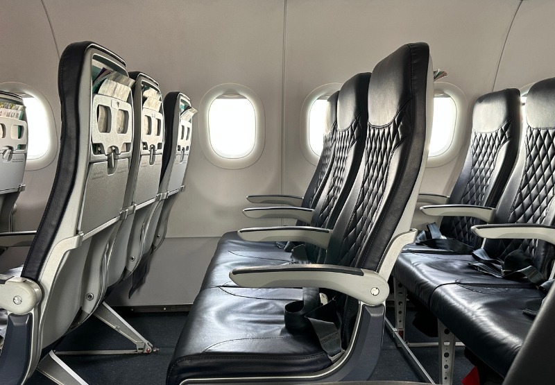 a view of inside of an airplane, with empty black seats.